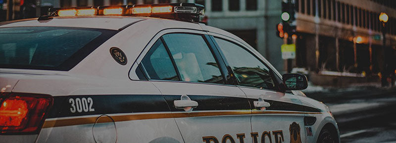 Law enforcement officer using iCloth to clean on-board tech surfaces, ensuring peak performance of touchscreens, mobile radar, and license plate readers in the squad car.